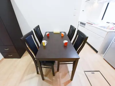 a dining room table with four chairs and a kitchen at Sumida Tatekawa House in Tokyo