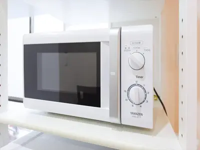 a white microwave sitting on a shelf at Sumida Tatekawa House in Tokyo