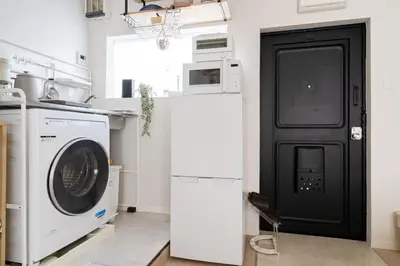 a kitchen with a washing machine and a refrigerator at Fuufu House Tokyo SHIBUYA - No Elevator 4F WalkUp in Tokyo