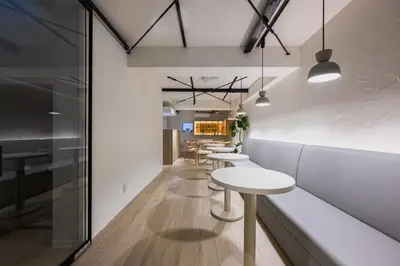 a row of tables and chairs in a room at The Gallery Stay Monnaka in Tokyo