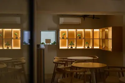 a dining room with tables and chairs and lights at The Gallery Stay Monnaka in Tokyo