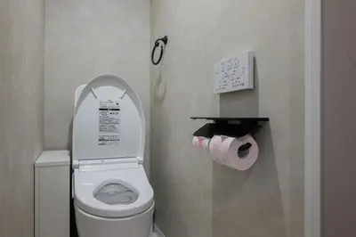 a bathroom with a toilet and a roll of toilet paper at The Gallery Stay Monnaka in Tokyo