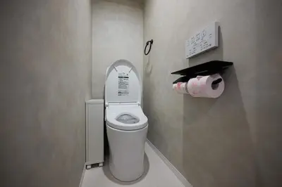 a small bathroom with a toilet with the lid up at The Gallery Stay Monnaka in Tokyo