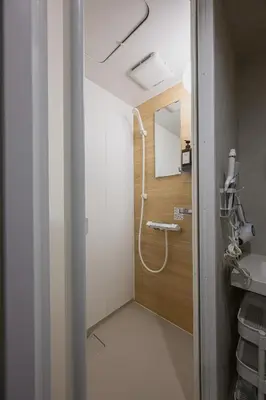 a bathroom with a shower and a mirror at The Gallery Stay Monnaka in Tokyo