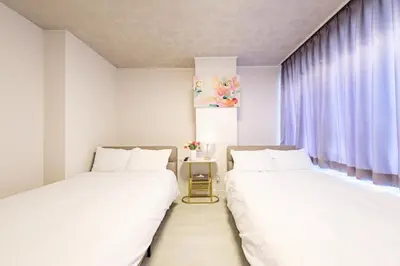 two beds sitting next to each other in a room at Liotta SHINBASHI A 7 beds, 7-minute walk from Shimbashi, up to 11 people in Tokyo