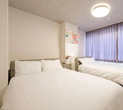 a white bedroom with two beds and a window at Liotta SHINBASHI A 7 beds, 7-minute walk from Shimbashi, up to 11 people in Tokyo