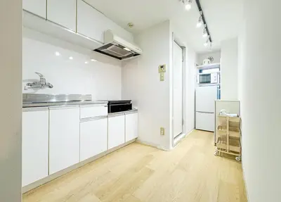 an empty kitchen with white cabinets and a refrigerator at Hotel-Mercurius-ShinOkubo-SBJB3F in Tokyo