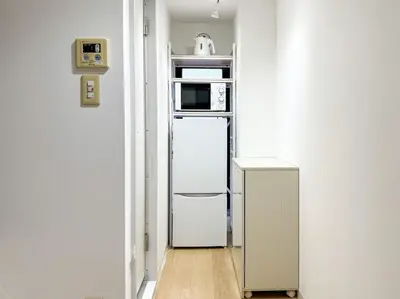 a kitchen with a white refrigerator and a microwave at Hotel-Mercurius-ShinOkubo-SBJB3F in Tokyo