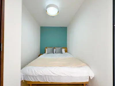 a bedroom with a bed with a blue wall at Hotel-Mercurius-ShinOkubo-SBJB3F in Tokyo