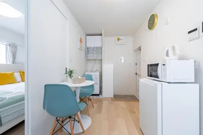 a small apartment with a small table and a refrigerator at \u304b\u3064\u3089201 in Tokyo