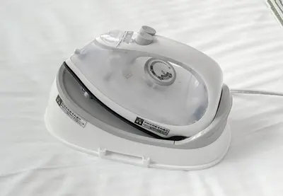 a white iron sitting on top of a bed at \u304b\u3064\u3089201 in Tokyo