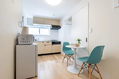 a kitchen with a table and two chairs and a refrigerator at \u304b\u3064\u3089201 in Tokyo