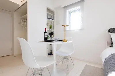 a white dining room with white chairs and a table at LIVCITY Kinshicho 202 in Tokyo