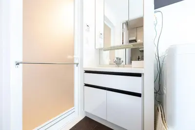 a kitchen with white cabinets and a refrigerator at LIVCITY Kinshicho 702 in Tokyo