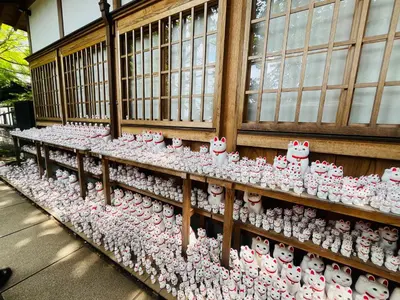 a display of hello kitty ceramics on a wall at Tokyo Maneki Stay Gotokuji in Tokyo