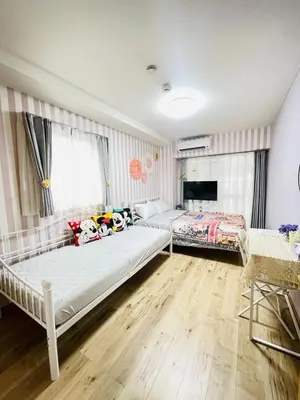 a bedroom with two beds and a tv at Shitamachi Shin-Koiwa 201 in Tokyo