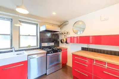 a kitchen with red cabinets and a stove at DM Hotel in Tokyo