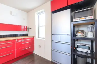 a red and white kitchen with red cabinets at DM Hotel in Tokyo