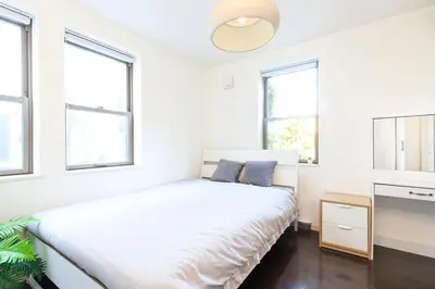 a white bedroom with a bed and windows at DM Hotel in Tokyo