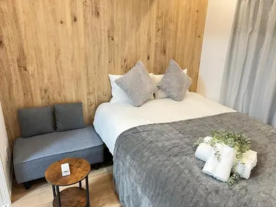 a bedroom with a large bed and a chair at Ikebukuro Area 1F01 NishiikeApartment in Tokyo