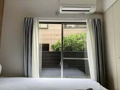 a bedroom with a bed and a sliding glass door at Ikebukuro Area 1F01 NishiikeApartment in Tokyo