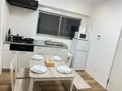 a small kitchen with a table and a white refrigerator at Ikebukuro Area 1F01 NishiikeApartment in Tokyo