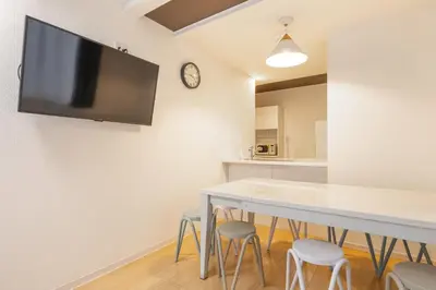 a dining room with a table with stools and a tv on the wall at NEW OPEN! 3bedroom house in Ikebukuro with a carp \u3048\u3060\u307e\u3081\u30a4\u30f3 in Tokyo