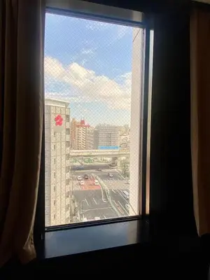 a window in a hotel room looking out at a city at daren stay in Tokyo