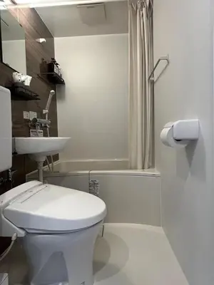 a white bathroom with a toilet and a sink at daren stay in Tokyo