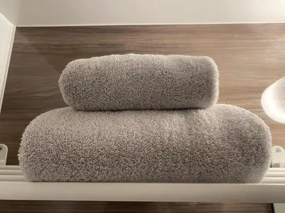 three towels stacked on top of each other on a shelf at daren stay in Tokyo