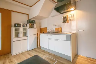 a kitchen with white cabinets and a white refrigerator at ichigo ichie 8minute walk HigashiMukojima Tokyo sightseeing in Tokyo