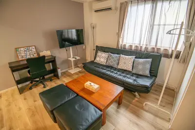 a living room with a black leather couch and a table at ichigo ichie 8minute walk HigashiMukojima Tokyo sightseeing in Tokyo