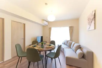 a living room with a couch and a table and chairs at AQUA RESIDENCE Sangenjaya by Tranova in Tokyo