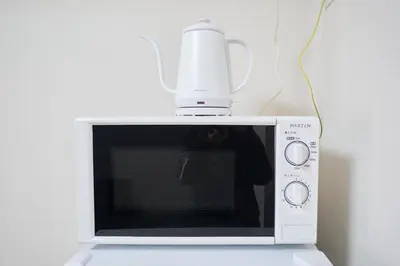 a white microwave with aurger on top of it at AQUA RESIDENCE Sangenjaya by Tranova in Tokyo