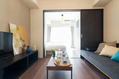 a living room with a couch and a table at AQUA RESIDENCE Sangenjaya by Tranova in Tokyo
