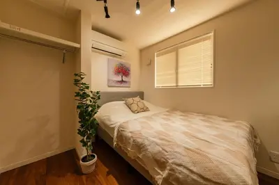 a bedroom with a bed and a plant in it at tai\u5357\u5143\u753a25 in Tokyo