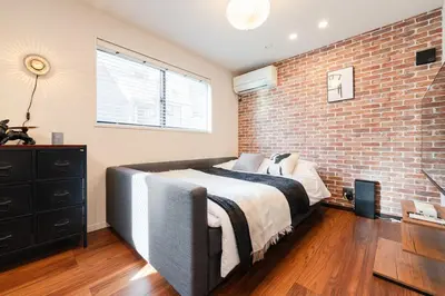 a bedroom with a brick wall and a bed at tai\u5357\u5143\u753a25 in Tokyo