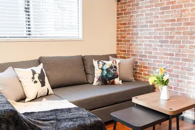 a living room with a couch and a brick wall at tai\u5357\u5143\u753a25 in Tokyo