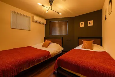 a bedroom with two beds with red sheets at tai\u5357\u5143\u753a25 in Tokyo