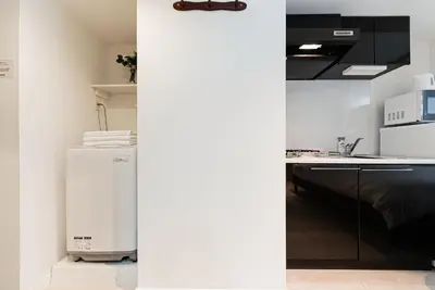a kitchen with a white refrigerator and a counter at NDZ101 3 min walk to station, 2 lines, Yamanote Line, high-speed Wi-Fi in Tokyo