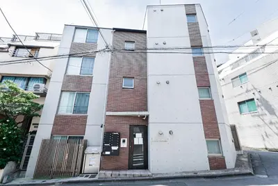 a tall brick building with a door on a street at NDZ101 3 min walk to station, 2 lines, Yamanote Line, high-speed Wi-Fi in Tokyo