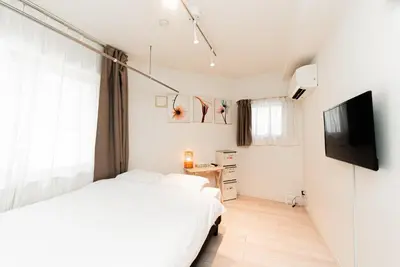 a bedroom with a bed and a flat screen tv at NDZ101 3 min walk to station, 2 lines, Yamanote Line, high-speed Wi-Fi in Tokyo