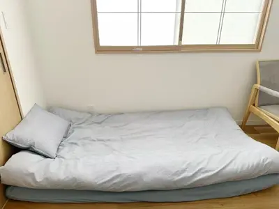 a bed in a room with a window at \u6587\u4eachouse 201\u5ba4 in Tokyo