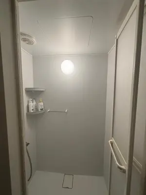 a bathroom with a shower with a light on the ceiling at \u6587\u4eachouse 201\u5ba4 in Tokyo