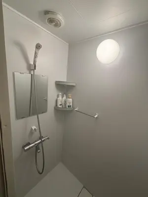 a bathroom with a shower with a light on the wall at \u6587\u4eachouse 201\u5ba4 in Tokyo