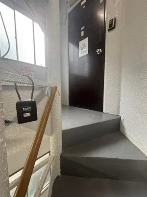 a black door on the side of a building with stairs at \u6587\u4eachouse 201\u5ba4 in Tokyo