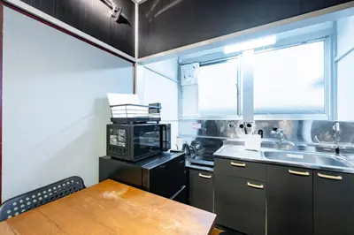a kitchen with a table and a microwave and a sink at AkebonoHouse103 in Tokyo