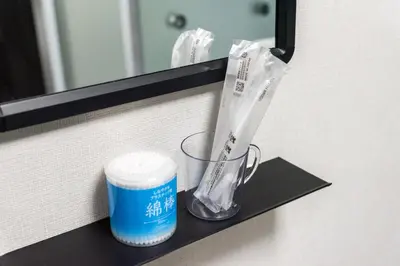 a bathroom shelf with a cup and toothbrushes at AkebonoHouse103 in Tokyo
