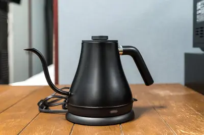 a black tea kettle sitting on a wooden table at AkebonoHouse103 in Tokyo