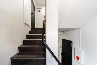 a stairwell in a building with a black door at NDZ103 3 min walk to station, 2 lines, Yamanote Line, high-speed Wi-Fi in Tokyo